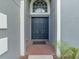 Elegant entryway with a double front door and transom window, set in a textured gray facade at 2812 Windcrest Oaks Ct, Valrico, FL 33594