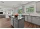 Bright kitchen features an island, gray cabinetry, and views of the outdoor pool area from the large windows at 2812 Windcrest Oaks Ct, Valrico, FL 33594