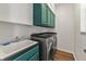 Efficient laundry room with sleek washer/dryer, stylish upper cabinets, and convenient utility sink at 2812 Windcrest Oaks Ct, Valrico, FL 33594
