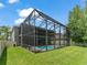View of the screened pool area from the backyard, featuring a spacious yard at 2812 Windcrest Oaks Ct, Valrico, FL 33594
