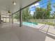 A screened-in pool area with a ceiling fan offers a relaxing view of the blue sky and green trees at 2812 Windcrest Oaks Ct, Valrico, FL 33594