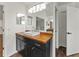 Bathroom vanity with modern lighting, wood counters, black cabinetry, and mirror at 2812 Windcrest Oaks Ct, Valrico, FL 33594