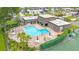 Aerial view of the Community pool, tennis court, and cabana, nestled in mature landscaping at 2980 Haines Bayshore Rd # 105, Clearwater, FL 33760