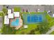 Aerial view highlighting community pool, tennis court, adjacent parking, and cabana at 2980 Haines Bayshore Rd # 105, Clearwater, FL 33760