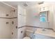 Bright bathroom featuring a shower, toilet, sink, and colorful accent tiles at 2980 Haines Bayshore Rd # 105, Clearwater, FL 33760