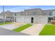 Townhouse exterior with garages, well-maintained landscaping, and a driveway at 2980 Haines Bayshore Rd # 105, Clearwater, FL 33760