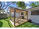 Backyard featuring a pergola-covered patio, grill, and artificial grass at 3127 W Oakellar Ave, Tampa, FL 33611