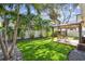 Backyard featuring a pergola-covered patio with furniture and a lush, green lawn at 3127 W Oakellar Ave, Tampa, FL 33611