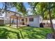 Backyard with pergola-covered patio, grill, and artificial grass at 3127 W Oakellar Ave, Tampa, FL 33611