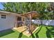 Backyard featuring a pergola-covered patio, grill, and artificial grass at 3127 W Oakellar Ave, Tampa, FL 33611