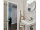 Bathroom featuring a pedestal sink, ladder, and decorative mirror at 3127 W Oakellar Ave, Tampa, FL 33611