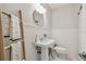 Bright bathroom featuring a pedestal sink, decorative ladder, and neutral tiling at 3127 W Oakellar Ave, Tampa, FL 33611