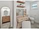Well-lit bathroom with vanity, lighted mirror, shelving, and modern fixtures at 3127 W Oakellar Ave, Tampa, FL 33611