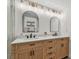 Bathroom featuring a double vanity with marble countertop, modern light fixtures, and mirrors at 3127 W Oakellar Ave, Tampa, FL 33611