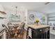 Cozy dining area features a wood table, chandelier, and a view into the living room at 3127 W Oakellar Ave, Tampa, FL 33611