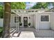 Attractive front entry with brick paved porch, pergola, modern door, and minimalist landscaping at 3127 W Oakellar Ave, Tampa, FL 33611
