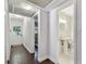 Hallway with wood floors and multiple doors leading to a bathroom at 3127 W Oakellar Ave, Tampa, FL 33611