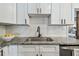 Modern kitchen features granite counters, a subway tile backsplash, and sleek black hardware at 3127 W Oakellar Ave, Tampa, FL 33611