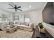 Well-lit living room offers a spacious seating arrangement, ceiling fan, hardwood floors, and a cozy atmosphere at 3127 W Oakellar Ave, Tampa, FL 33611