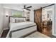 Comfortable main bedroom featuring a queen-sized bed and a rustic barn door to the dining room at 3127 W Oakellar Ave, Tampa, FL 33611