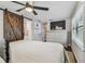 Stylish main bedroom with a TV, dresser, and a rustic sliding barn door at 3127 W Oakellar Ave, Tampa, FL 33611