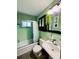 Bathroom with a bathtub and shower, and a vanity with sink featuring trendy green tiling at 3135 33Rd N Ave, St Petersburg, FL 33713