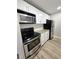 Galley kitchen boasts granite countertops, stainless appliances, white cabinets, and wood look tile at 3325 Bayshore Blvd # C14, Tampa, FL 33629