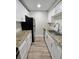 Galley kitchen boasts granite countertops, stainless appliances, white cabinets, and wood look tile at 3325 Bayshore Blvd # C14, Tampa, FL 33629