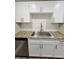 Galley kitchen boasts granite countertops, stainless appliances, white cabinets, and wood look tile at 3325 Bayshore Blvd # C14, Tampa, FL 33629