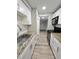 Galley kitchen boasts granite countertops, stainless appliances, white cabinets, and wood look tile at 3325 Bayshore Blvd # C14, Tampa, FL 33629