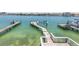 View of the wood private dock with boat lift on clear water, perfect for boating and fishing at 340 Bay Plaza, Treasure Island, FL 33706