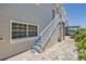 Charming exterior featuring a stairway with sturdy white railings and a brick path leading to the marina at 340 Bay Plaza, Treasure Island, FL 33706