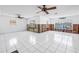 Bright living area with white tile flooring, ceiling fans, and large waterfront-facing windows at 340 Bay Plaza, Treasure Island, FL 33706