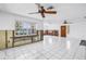 Open living space with white tile flooring, ceiling fans, and waterfront views from the windows at 340 Bay Plaza, Treasure Island, FL 33706