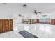 Open-concept living room with white tile floors, water views, and ceiling fans at 340 Bay Plaza, Treasure Island, FL 33706