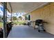Relaxing covered back porch with a grill, seating, and well-maintained landscaping, ideal for outdoor enjoyment at 3707 Cambridge St, New Port Richey, FL 34652