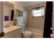 Bathroom featuring a combination shower and tub, toilet, vanity, and neutral tiling at 3707 Cambridge St, New Port Richey, FL 34652