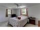 Cozy bedroom with two cats lounging on a bed beneath a ceiling fan and windows at 3707 Cambridge St, New Port Richey, FL 34652
