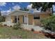 Charming home with a covered front porch, manicured landscaping, and cozy seating area at 3707 Cambridge St, New Port Richey, FL 34652