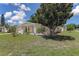 Inviting single-story home featuring a well-maintained lawn, mature tree, and a welcoming front porch at 3707 Cambridge St, New Port Richey, FL 34652