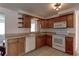 Well-lit kitchen with wood cabinets, white appliances, a double sink, and tile flooring at 3707 Cambridge St, New Port Richey, FL 34652