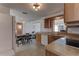 Kitchen with wood cabinets, tile flooring, white appliances, and a view into an adjacent room at 3707 Cambridge St, New Port Richey, FL 34652