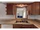 Kitchen featuring a stainless steel double sink, wood cabinetry, neutral countertops, and a window at 3707 Cambridge St, New Port Richey, FL 34652