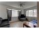 Bright living room with tile flooring, large windows with curtains, and comfortable seating at 3707 Cambridge St, New Port Richey, FL 34652