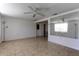 Spacious living area with tile flooring, a ceiling fan, and a decorative mirror at 3707 Cambridge St, New Port Richey, FL 34652