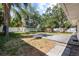Fenced backyard featuring a large, flat backyard, lush trees, and a gray patio at 3907 W Azeele St, Tampa, FL 33609