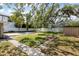Beautiful backyard with a brick pathway, lush lawn, privacy fence, and lots of green trees at 3907 W Azeele St, Tampa, FL 33609
