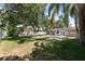 Large, fenced backyard featuring an expansive green lawn, lush trees, and a patio at 3907 W Azeele St, Tampa, FL 33609