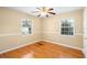 A bedroom with hardwood floors, two windows, and a ceiling fan with light fixture at 3907 W Azeele St, Tampa, FL 33609