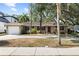 Charming single-story home with a well-manicured lawn, mature trees, and an attached garage at 3907 W Azeele St, Tampa, FL 33609